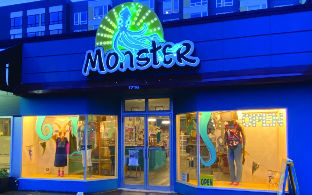 Photo of exterior of a storefront in the evening with the Monster logo