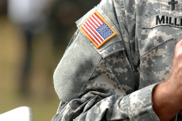 Closeup of a shoulder patch of an American flag on a U.S. Military uniform.