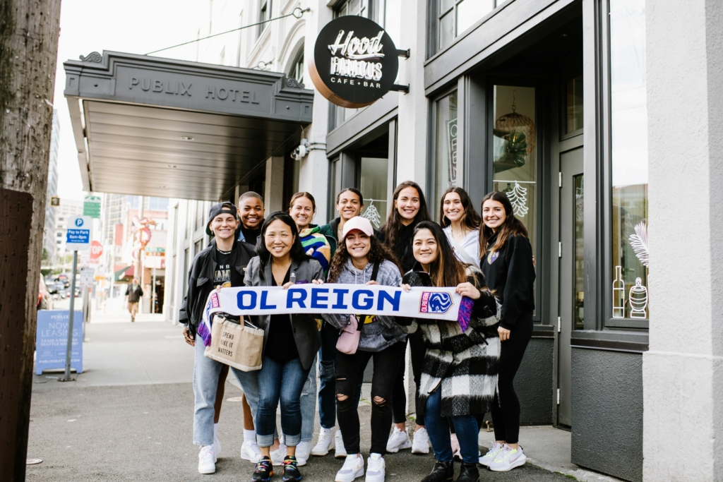 OL Reign players pose with Chera Amlag outside Hood Famous Cafe + Bar in Seattle's Chinatown-International District.