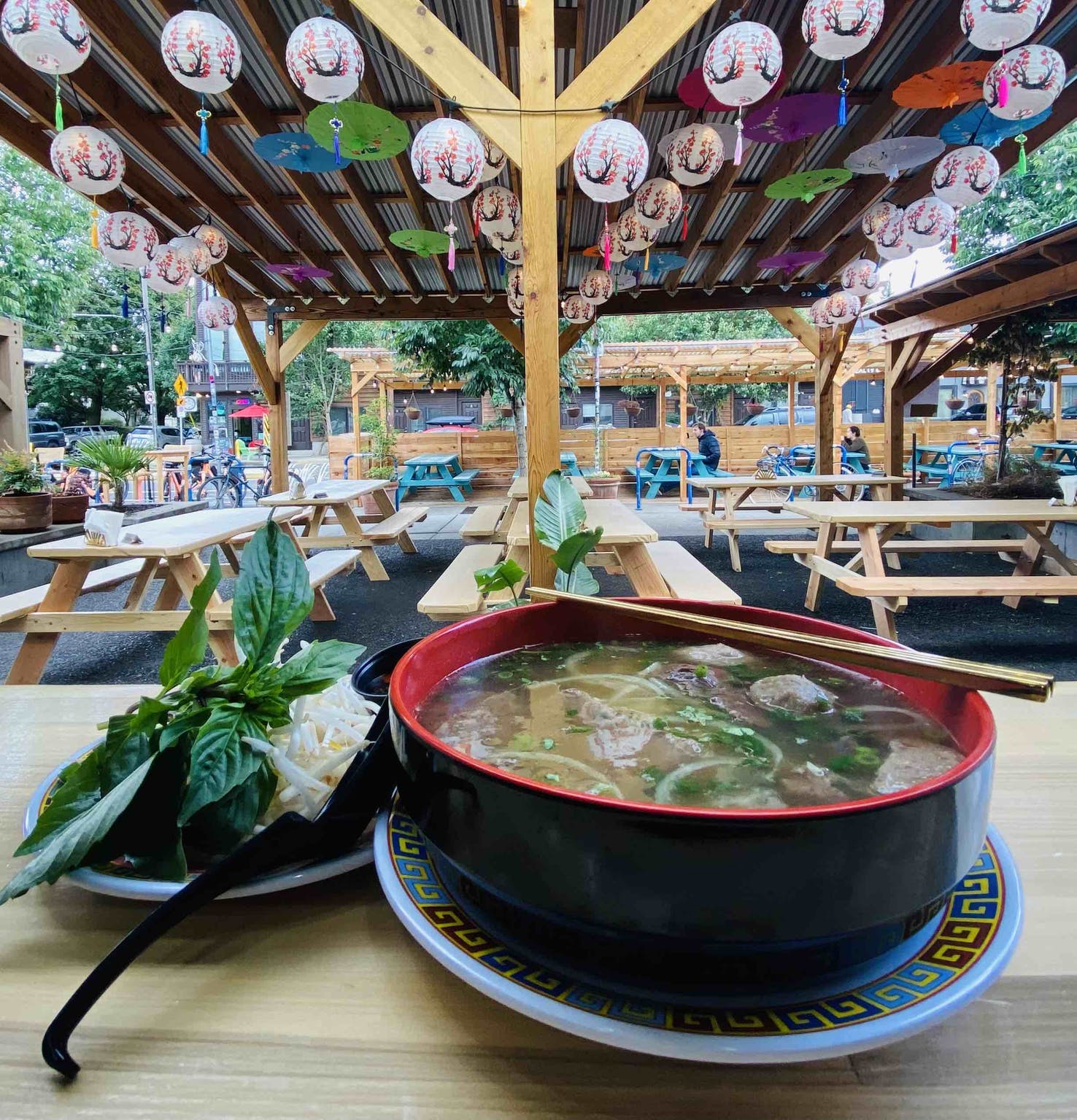 Patio seating at restaurant and bowl of noodle soup