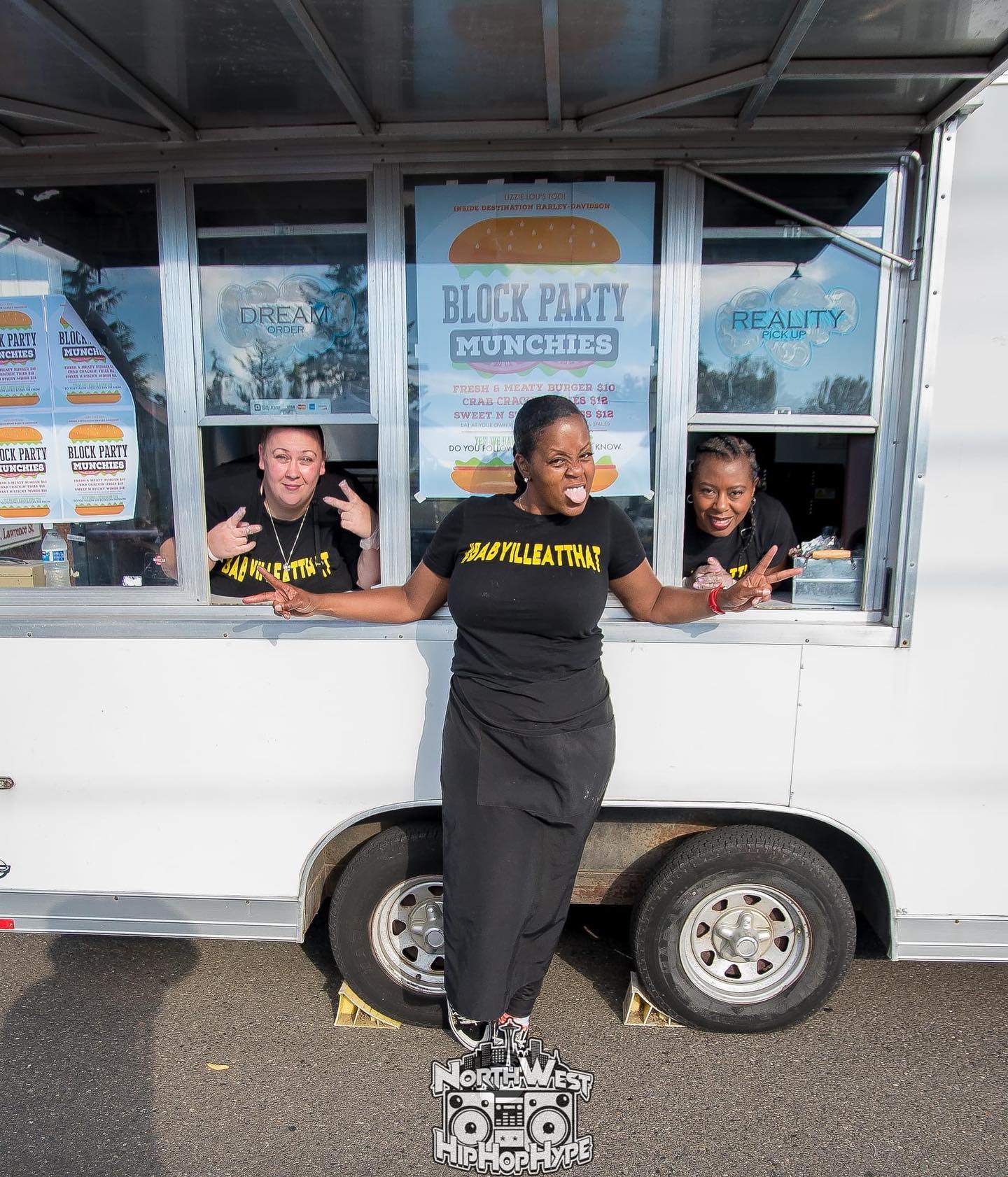 Owner Nessa standing in front of her food truck, Lizzie Lou's, with her cooks looking out of the windows