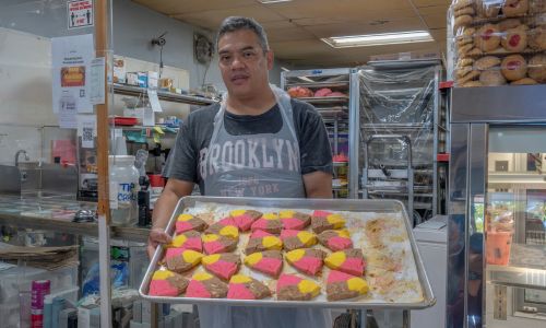 Las Delicias Panaderia Y Antojitos owner holding a tray of cookies